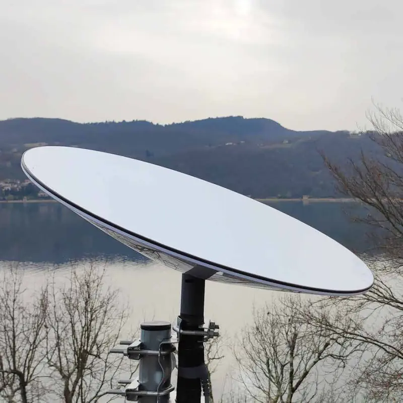 Antenne Starlink installée sur un mât, face à un lac